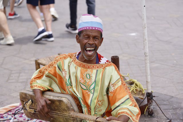 Musician in Traditional Moroccan Clothing Playing a Gnawa.jpg